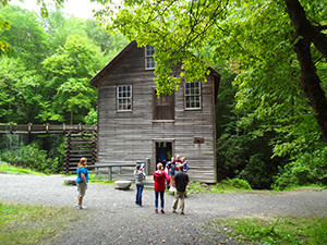 people standing by an old mill