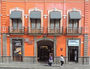 an orange-colored building with wrought-iron balconies, one of the things to see in Puebla