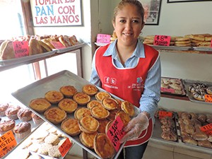 woman holding tray of pastries