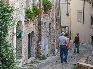 people walking down a small street in an Italian hill town