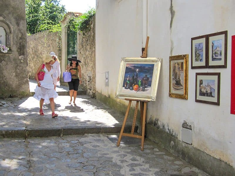 3 young women looking at paintings outside an art shop