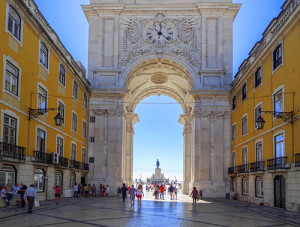 people walking by a large arch
