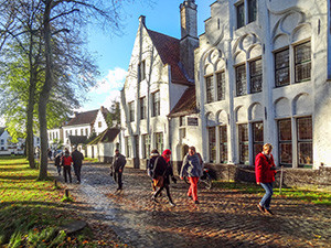 people walking by an old building