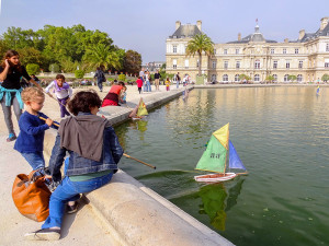 boy sailing a boat on a pond