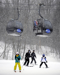 skiers under ski gondolas