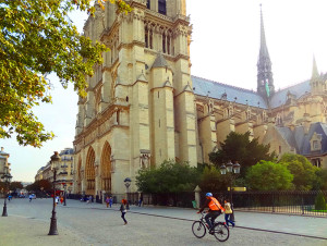 A bicyclist bear a cathedral
