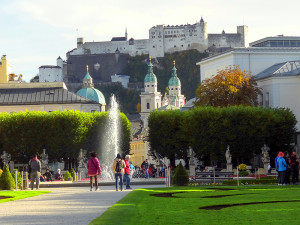 people in a park looking at a castle on a hill