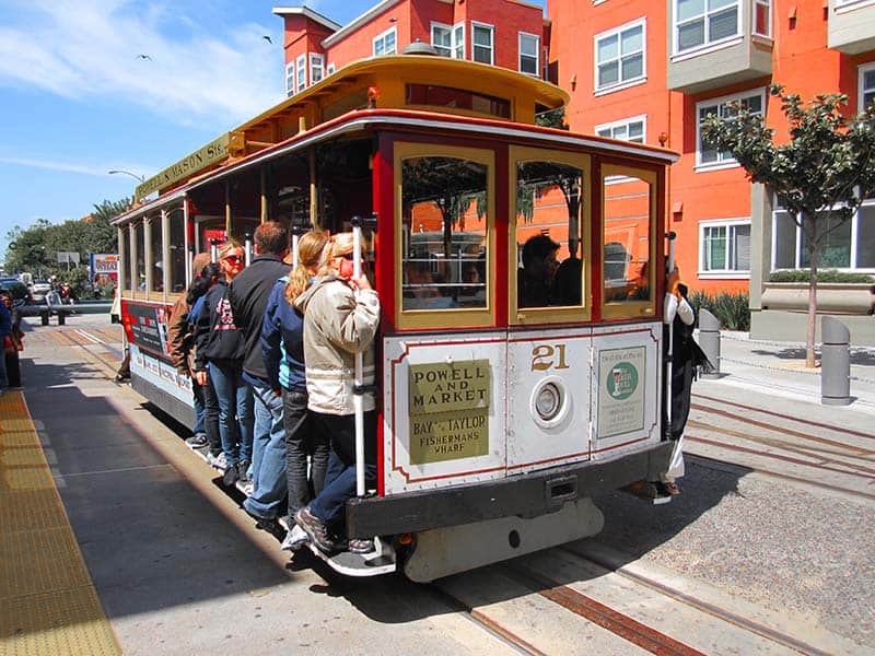 people riding a cable car, one of the things to do during 3 days in San Francisco