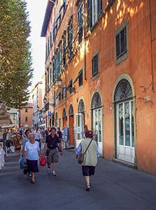 people on a street with an orange building