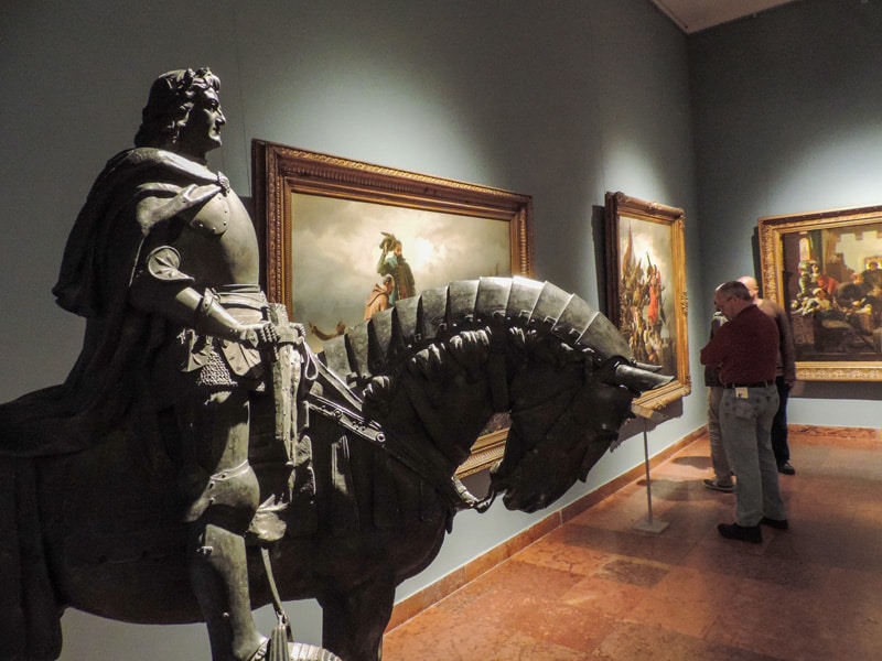 a man looking at a painting in a museum