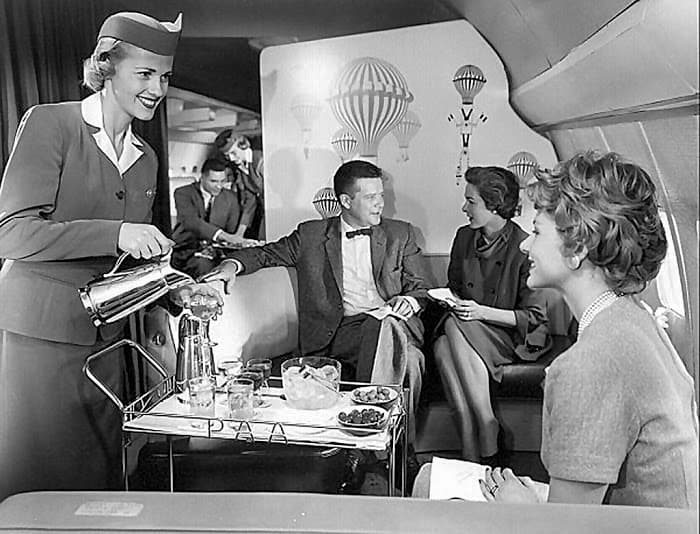 people dressed up on a plane during the early days of air travel
