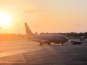 plane on runway at sunset – save money on flights