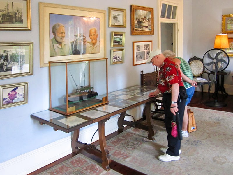 people looking at an exhibit in Hemingway's Key West home - one of the homes of famous writers
