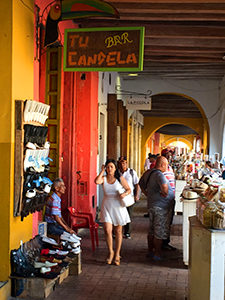 a woman walking along a colonnade in Cartagena