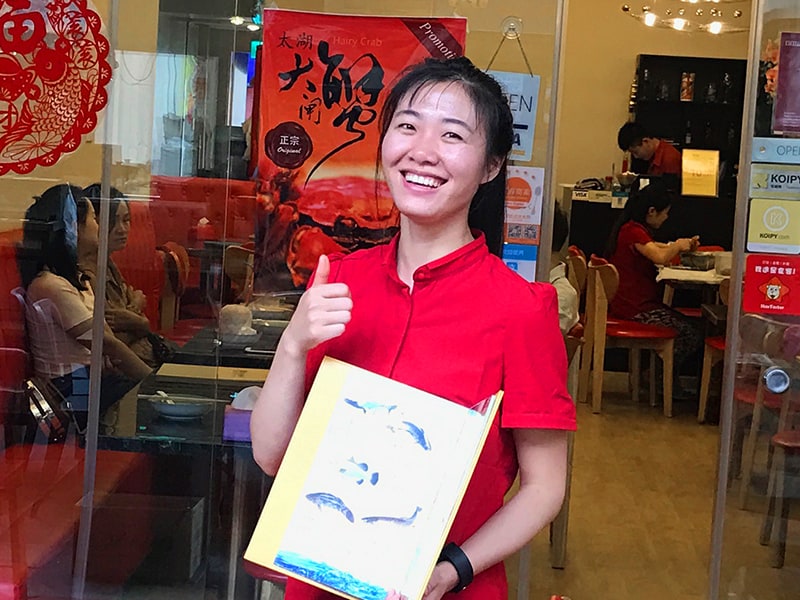 a woman standing in a doorway in a  restaurant, one of the things Singapore is famous for