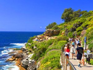 people walking along teh ocean in Sydney