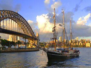 a boat in the harbor by a bridge in Sydney