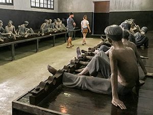 people walking through a prison museum in Hanoi