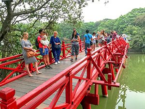 people on a red-painted bridge in Hanoi