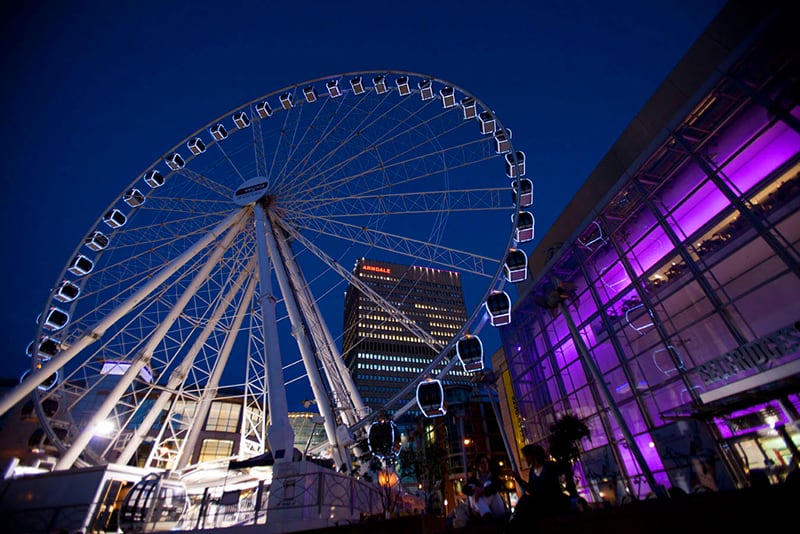a Ferris wheel and buildings at night in England