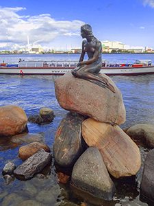 a statue on teh water's edge in Scandinavia