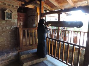 a nun standing by a railing in Meteora