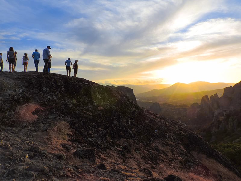 people on a hill at sunset