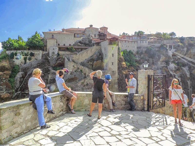 people on an overlook viewing Meteora monasteries