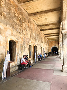 people sitting on benches in an old fort - one of the things to do in Old San Juan