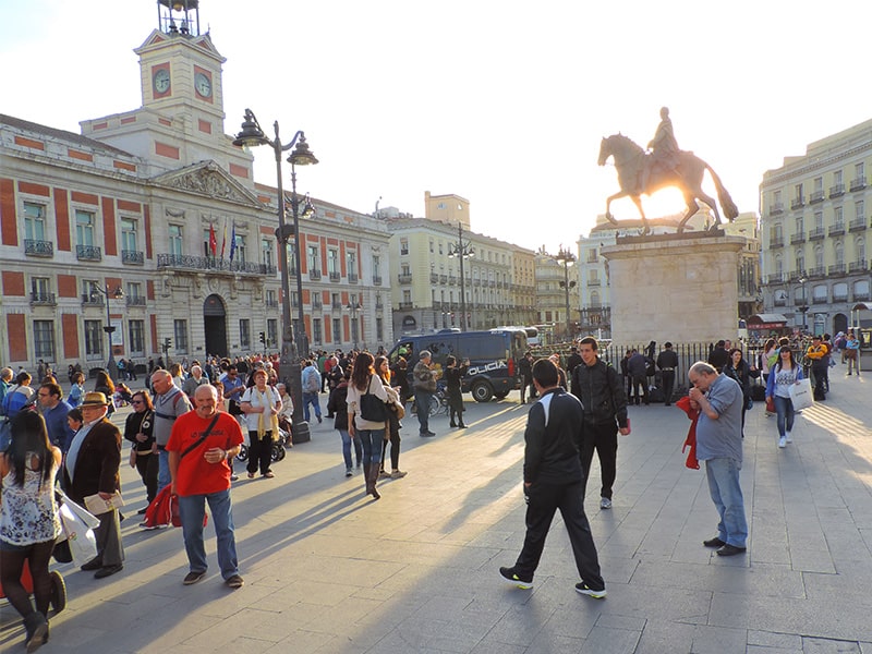 people walking in a city square, one of the things to do in Madrid