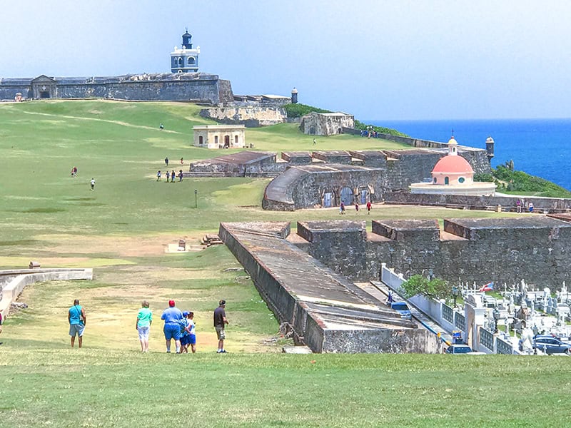 a huge fort atop a hill seen from a park