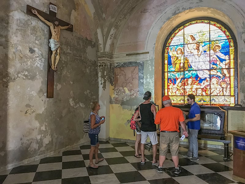 people by a bright stained-glass window in an ancient church