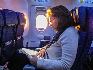 woman on a plane Budget Travel Tips