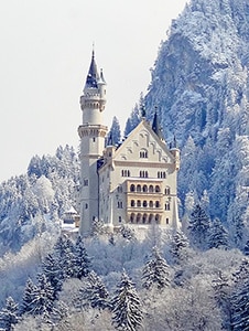 a castle in snowy mountains in one of the places to visit in Bavaria