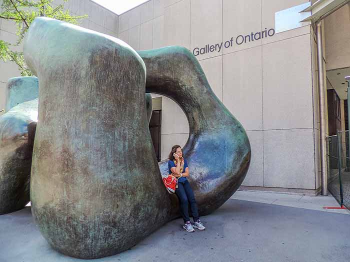 woman sitting on a sculpture in Toronto