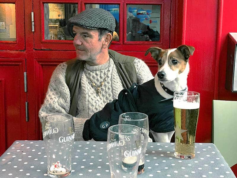 a man at a pub with his dog, one of the things to do in Galway
