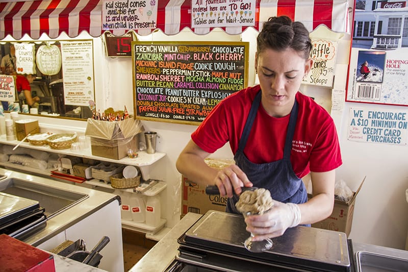 boy scooping ice cream in an icream parlor 