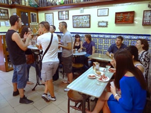 people sitting at tables in a bodega