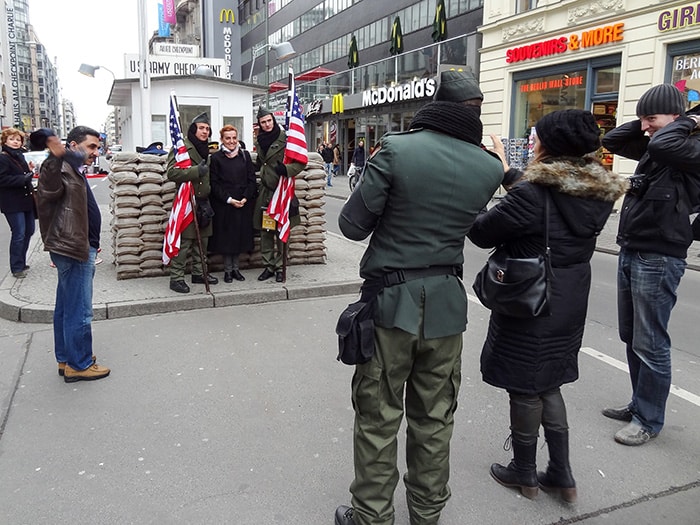 people having their photo taken at Checkpoint Charlie, one of The Best Things To Do In Berlin, Germany