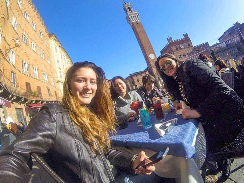 3 students at a cafe table in Italy study abroad
