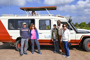 people standing by a van on safari in kenya