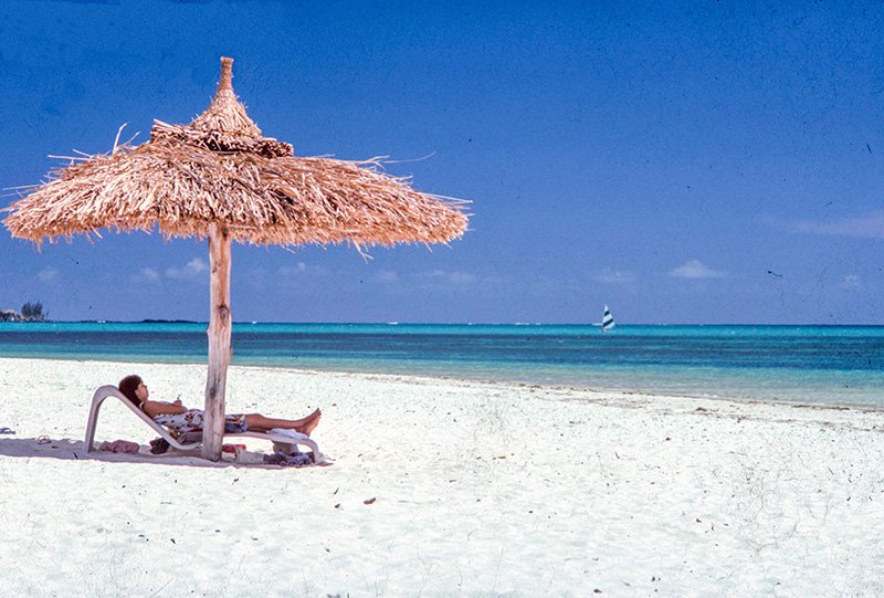 a women relaxing on a beach - travel insurance