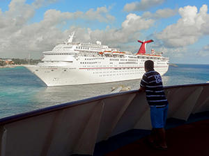 man looking at a cruise ship - travel insurance