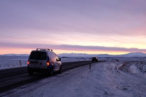 cars on road at sunrise - Iceland ice caves