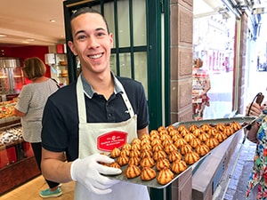 a young man with a tray of macaroons