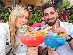 two young people with huge colorful cocktails