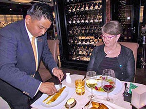 waiter de-boning fish in a Silver Muse restaurant