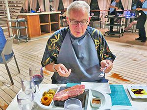 man eating steak on Silversea Muse