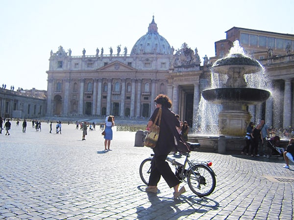 woman walking a bike in St peter's Square top 10 in Italy