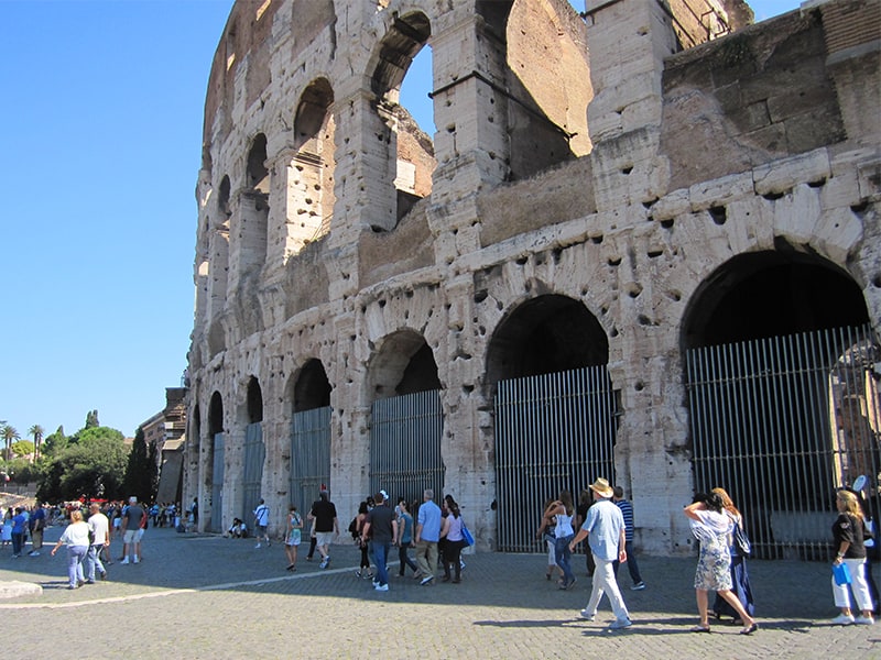 people walking outside Rome's Colosseum, one of the best places to visit in Italy